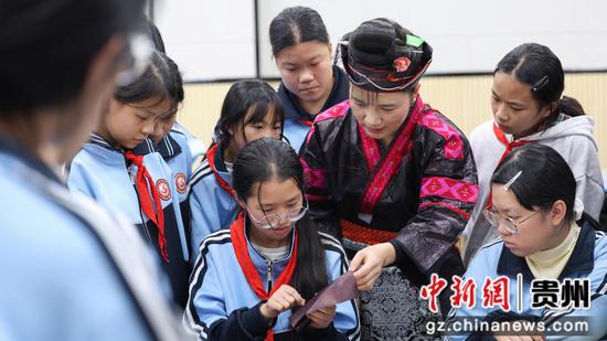 10月27日，省级代表性传承人杨丽在剑河县第五中学社团教室与学生交流苗族刺绣（红绣）技艺。