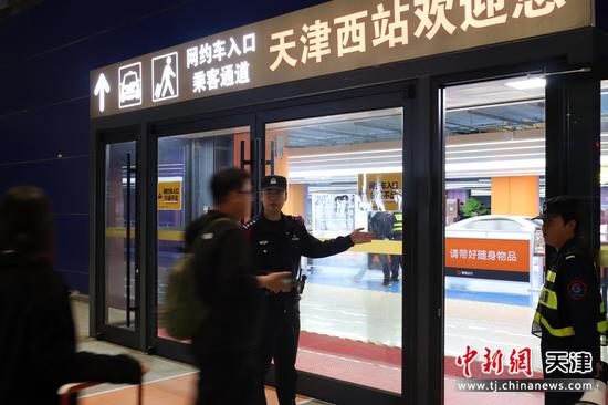 图为北京铁路公安局天津公安处天津西站派出所执勤民警在网约车乘车点为旅客答疑解惑。(北京铁路公安局天津公安处供图) 图为北京铁路公安局天津公安处天津西站派出所执勤民警在网约车乘车点为旅客答疑解惑。(北京铁路公安局天津公安处供图)