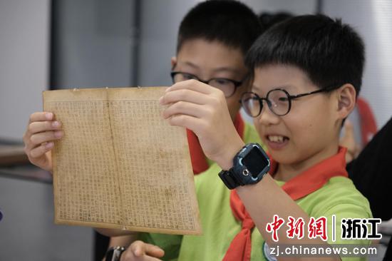 7月8日，学生拿起纸张检查档案修复效果。曹丹&nbsp;摄