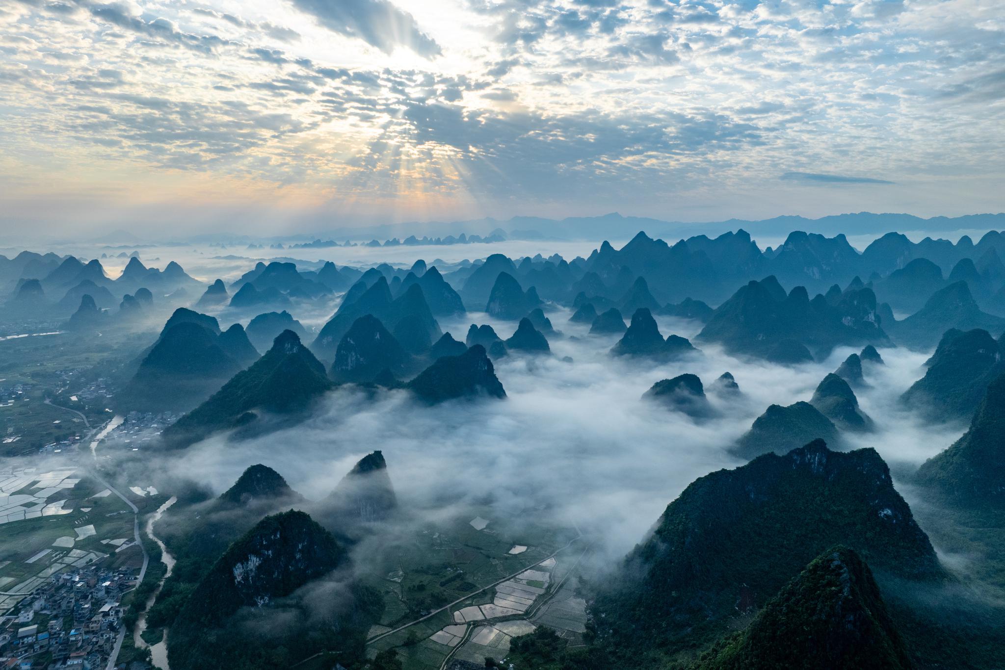 Sunrise scenery over karst formation mountain in mist