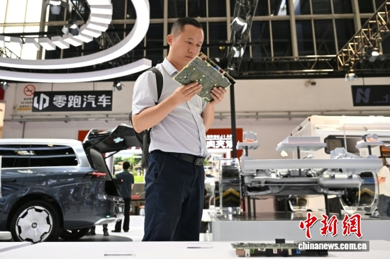 A visitor examines circuit boards on a new energy vehicle at the 4th China International Supply Chain Expo held in Beijing, June 23, 2026. (Photo: China News Service/Zhao Wenyu)
