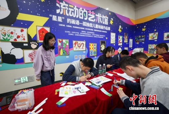 Children with autism make bookmarks at an exhibition of paintings by children with autism in Beijing, April 2, 2026. (Photo: China News Service/Jia Tianyong)