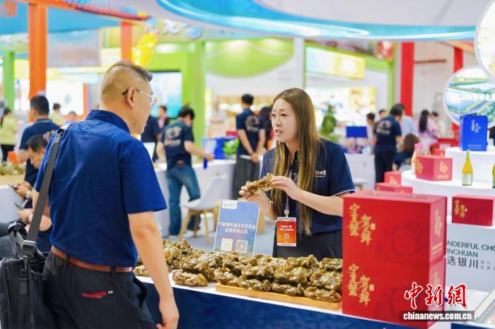 An exhibitor promotes mitten crabs raised in the saline-alkali waters of Helan County to visitors during the third Shanghai International Crab Industry Expo. (Photo: Yuan Wenbin)