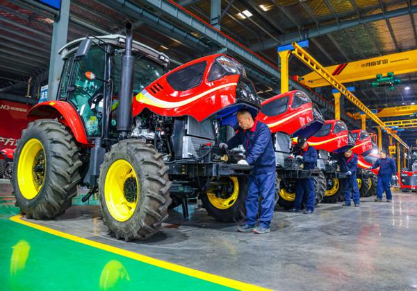 Staff workers conduct the final check for tractors to be sold in a factory in Yangzhou, Jiangsu province, on Jan 19, 2026. (Photo: Xinhua)