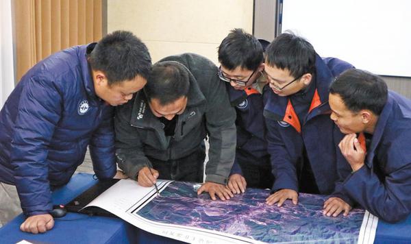 Geological workers discuss the day's findings at a summary session. (Photo: Li Menghan/ China Daily)