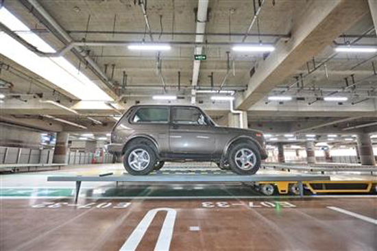 A car is hoisted up into a parking space at the Beijing Capital International Airport. (Photo/Beijing News)