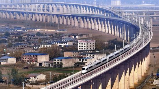 A high-speed train of the Beijing-Tangshan Intercity Railway crosses a bridge in Tangshan, Hebei province. (Photo by Liu Quanguo/For chinadaily.com.cn)