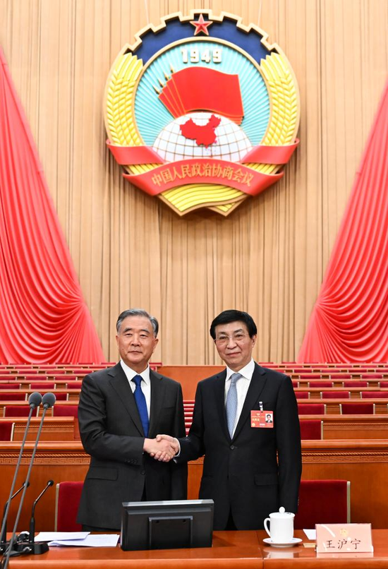 Wang Yang, chairman of the 13th National Committee of the Chinese People's Political Consultative Conference (CPPCC), shakes hands with Wang Huning, who presides over a presidium meeting of the first session of the 14th CPPCC National Committee, during a preparatory meeting for the first session of the 14th CPPCC National Committee at the Great Hall of the People in Beijing, capital of China, March 3, 2023. (Xinhua/Xie Huanchi)