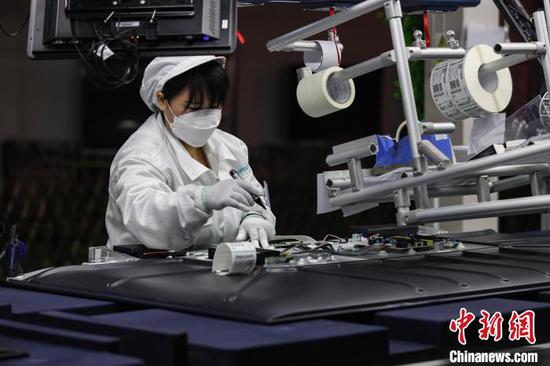 A worker assembles televisions in a production workshop of Hisense in Guiyang, Guizhou Province. (Photo provided to China News Service)