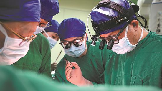 Doctors conduct a heart transplant on a 53-day-old girl at the Union Hospital Affiliated to Tongji Medical College at the Huazhong University of Science and Technology in Wuhan, Hubei province, on Feb 26. (CHINA DAILY)