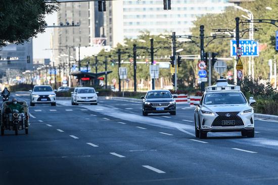 An autonomous vehicle (1st R) is in driverless test on a road in Yizhuang of Beijing, capital of China, Oct. 19, 2021.(Xinhua/Peng Ziyang)