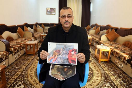 A photo taken on Feb. 10, 2023 shows Khalid Salman Rasif holding pictures of some of the victims of the Haditha massacre. Many family members of Rasif were killed during the massacre, which was committed by American soldiers on Nov. 19, 2005 in western Iraq. (Xinhua/Khalil Dawood)
