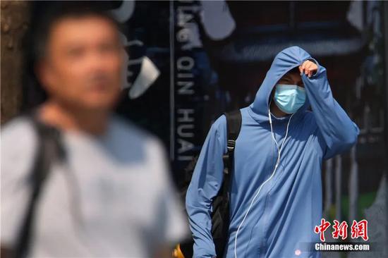 Photo taken on August 8, 2022 shows a man protects himself from scorching sun in E China's Nanjing City. (Photo: China News Service/ Yang Bo)