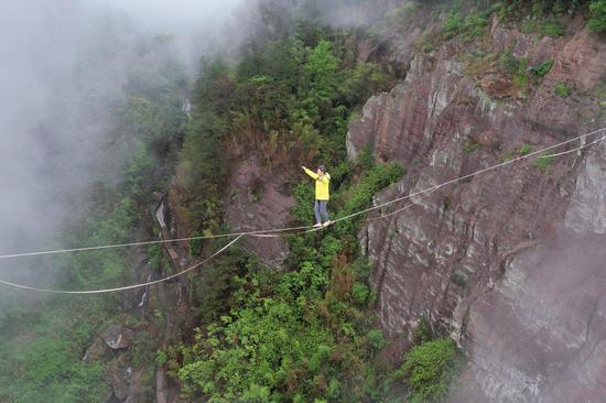 Tightrope walker crosses 300-meter long valley in Hunan