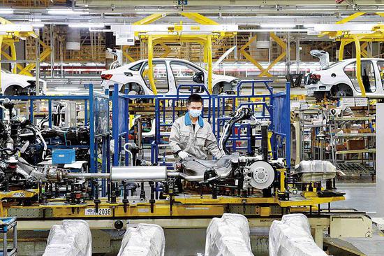 A Volkswagen employee works on an assembly line in Chengdu, Sichuan province, in December. (WANG QIN/FOR CHINA DAILY)