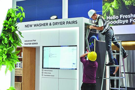 Workers set up exhibition booths at the venue of the upcoming 134th China Import and Export Fair in Guangzhou, Guangdong province. (PHOTO： CHEN JIMIN/CHINA NEWS SERVICE)