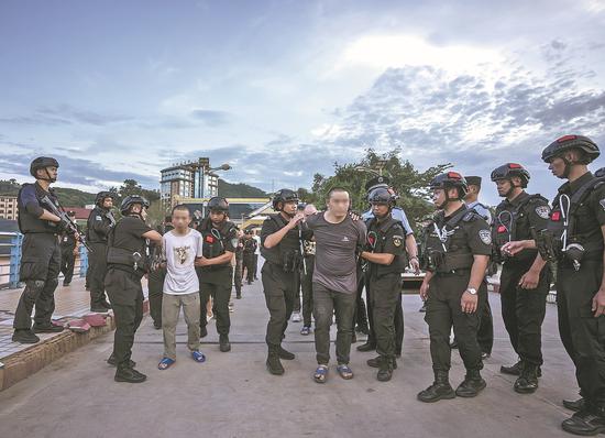 Fraud suspects are handed over to Chinese police in Pu'er, Yunnan, on Sept 6. (Photo/China Daily)