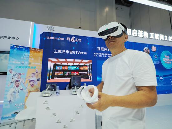 A visitor experiences Gongti Metaverse livestreaming during the Global Digital Economy Conference 2023 in Beijing on July 5.  (Photo: Du Jinapo/For China Daily)