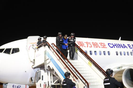 Major criminal suspects are escorted back to China from Myanmar on Tuesday. (Photo provided to China Daily)