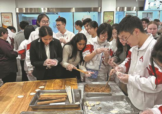 Muscatine students learn how to make dumplings in Beijing during their 10-day trip to China in January. (Photo / CHINA DAILY)