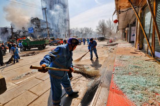 Photo taken on March 13, 2024, shows rescue workers cleaning up shattered glass at the scene of the explosion at a residential community in Xiaozhanggezhuang village of Yanjiao, North China's Hebei province. (Photo by Cao Boyuan/Provided to China Daily)