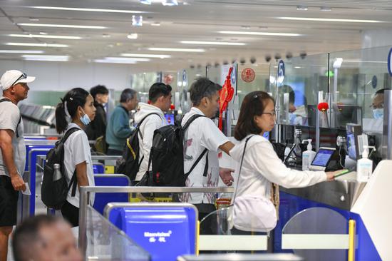 Inbound passengers go through entry procedures at Haikou Meilan International Airport in Hainan province on March 1. (LUO YUNFEI/CHINA NEWS SERVICE)
