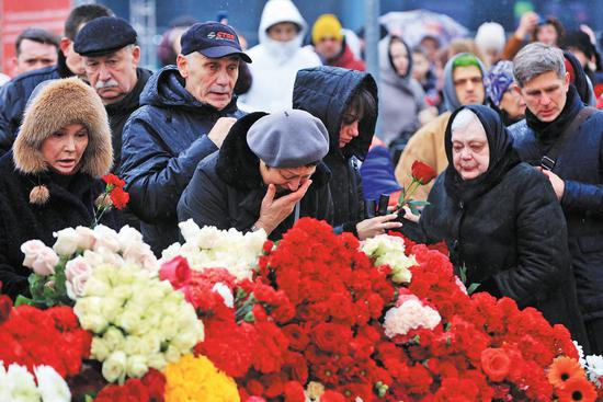 Moscow citizens lay flowers and mourn for victims at Crocus City Hall concert venue in the northwest of Moscow on Sunday,<strong></strong> the day of which President Vladimir Putin announced as National Day of Mourning. (REN QI/CHINA DAILY)