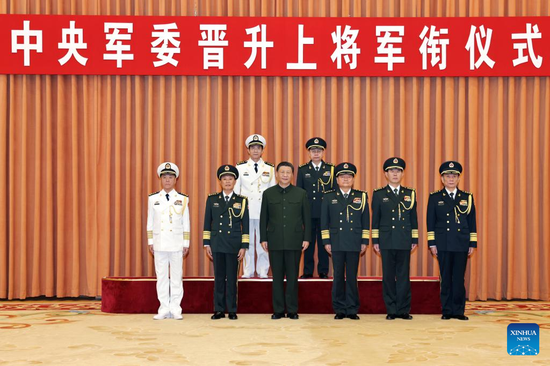 Xi Jinping, chairman of the Central Military Commission (CMC), and other leaders pose for a group photo with two military officers who have been promoted to the rank of general at a ceremony held by the CMC in Beijing, capital of China, March 28, 2024. Xi presented certificates of order to the officers and extended his congratulations to them. (Xinhua/Li Gang)