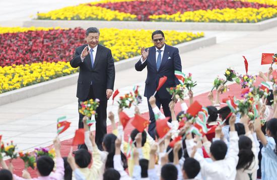 President Xi Jinping and visiting Surinamese President Chandrikapersad Santokhi attend a welcome ceremony at the Great Hall of the People in Beijing on Friday. (FENG YONGBIN/CHINA DAILY)