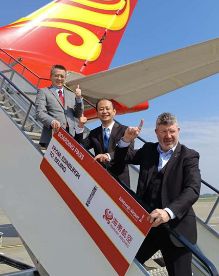 Chinese Consul General in Edinburgh Zhang Biao (first from left), Chief Executive of Edinburgh Airport Gordon Dewar (first from right), and Han Zhi, general manager of Hainan Airlines in the United Kingdom, attend an event on May 17 celebrating the resuming of the direct flights between Beijing and Edinburgh at Edinburgh Airport. (Photo provided to China Daily)