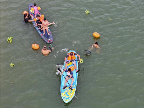Stand-up paddleboarding popular among citizens in central China City to beat summer heat