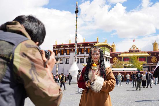 Global tourists dressed in Tibetan attire experience local culture in Lhasa