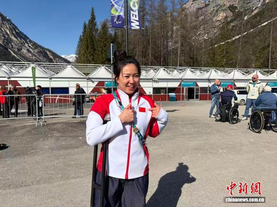Photo released on March 5, 2026 shows Para alpine skier Liu Sitong in front of the Olympic Village in Cortina. (Photo/China News Service)