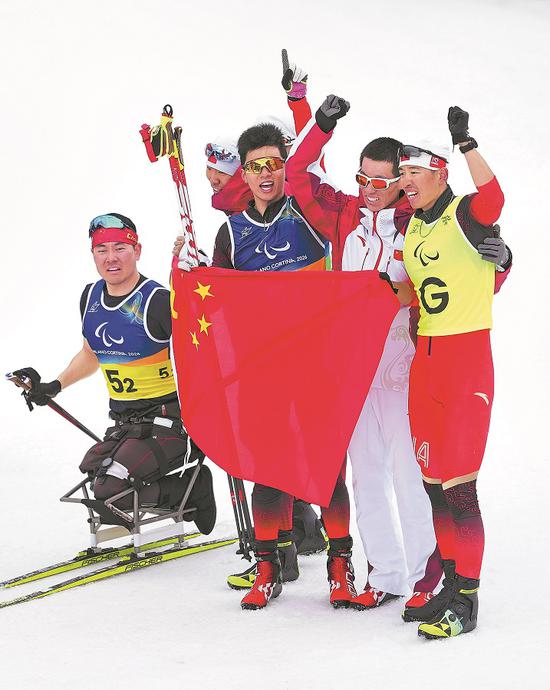 Members of the Chinese team celebrate on Saturday after winning the 4X2.5 km open relay cross-country skiing event of the Milano-Cortina 2026 Paralympic Winter Games in Tesero, Italy. (HOU ZHAOKANG/XINHUA)