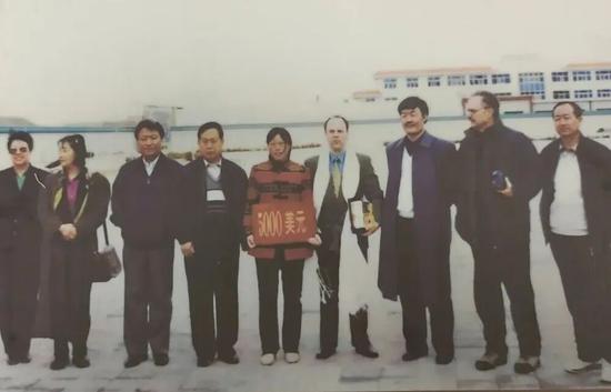 Ronald Sakolsky donates $5,000 to Yin Yuzhen for Yin’s cause of turning the Mu Us desert in Inner Mongolia into a forest. (Photo/People’s Daily)