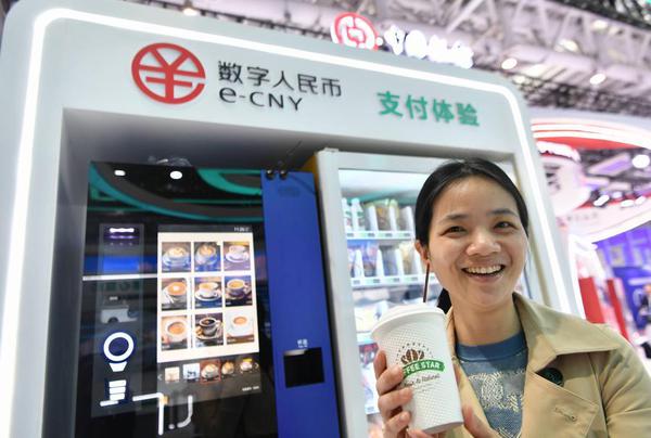 A visitor displays a cup of coffee purchased with China's digital yuan, or the e-CNY, at an exhibition of the 6th Digital China Summit in Fuzhou, east China's Fujian Province, April 26, 2023. (Xinhua/Wei Peiquan)