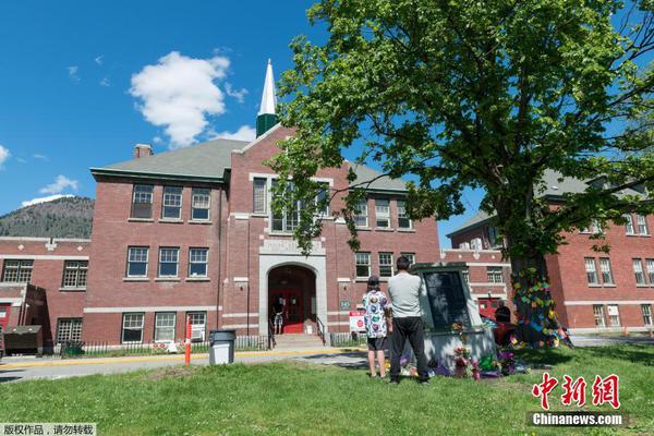 People lay flowers at a memorial for survivors of the former Kamloops Indian Residential School in Kamloops, British Columbia, Canada, on May 29, 2021. A day earlier, the remains of 215 Indigenous children were found at the site of the former residential school