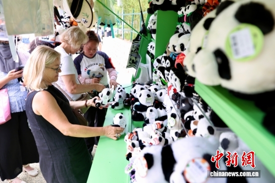 Two European tourists shop for panda souvenirs at Beijing Zoo on July 16, 2026. (Photo: China News Service/Yi Haifei)