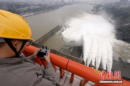 A staff member uses a drone to monitor dam operations at Danjiangkou Reservoir on October 22, 2025. (Photo: China News Service/Yin Liqin)