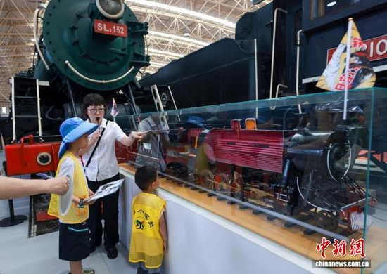 A guide describes a steam train to children at the China Railway Museum’s Dongjiao Exhibition Hall in Beijing, July 18, 2026. (Photo: China News Service/ Jia Tianyong)