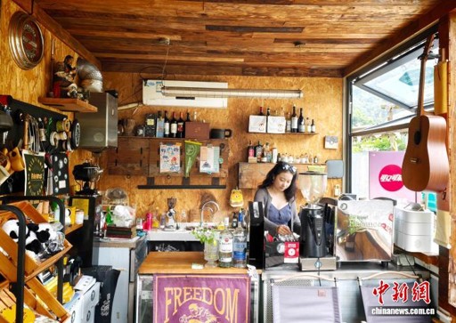 A barista prepares coffee at a rural café in Tongmu Village, Changsha, Hunan Province, August 7, 2026. (Photo: China News Service/ Tang Xiaoqian)