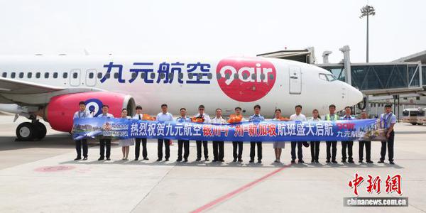 Crew members of pose for a group photo with the aircraft at Yinchuan Airport. (Photo: China News Service/Wang Chen)