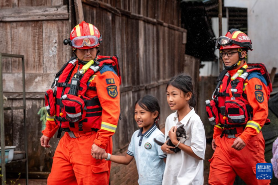 Firefighters evacuate children to a temporary shelter in Molong Village, Mohan Town, Yunnan Province, Aug. 30, 2026. (Photo: Xinhua)
