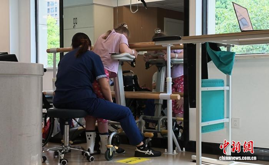Vera undergoes rehabilitation training under the guidance of a therapist. (Photo: China News Service/Zhang Yuhuan)