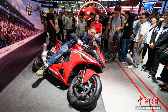 A foreign visitor tries exhibition motorcycles at the China International Motorcycle Trade Echibition in Chongqing on September 19, 2026. (Photo: China News Service/He Penglei)