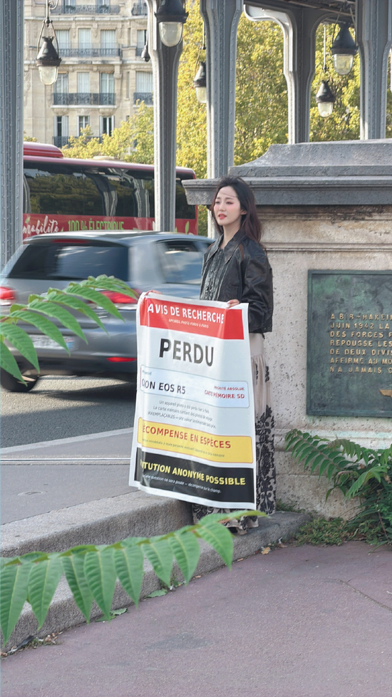Chinese actress Wan Qianhui holds a poster while searching for her stolen camera on a street in Paris. (Photo: Wan Qianhui's social media account)