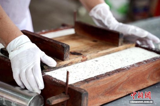 Zhong Huiqun makes Ligao glutinous rice cakes. (Photo: China News Service/Ya Chunliu)