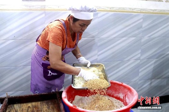 Zhong Huiqun makes Ligao glutinous rice cakes. (Photo: China News Service/Ya Chunliu)
