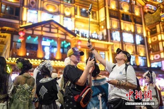 Foreign tourists take photos in front of Hongya Cave in Chongqing, Oct. 5, 2026. (Photo: China News Service)