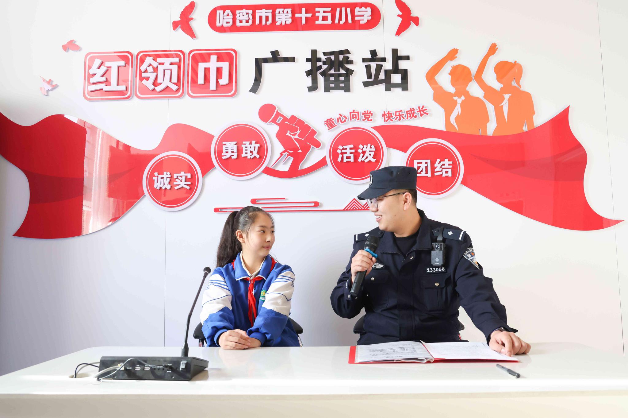民警与学生在广播站通过广播形式开展安全知识讲解。
